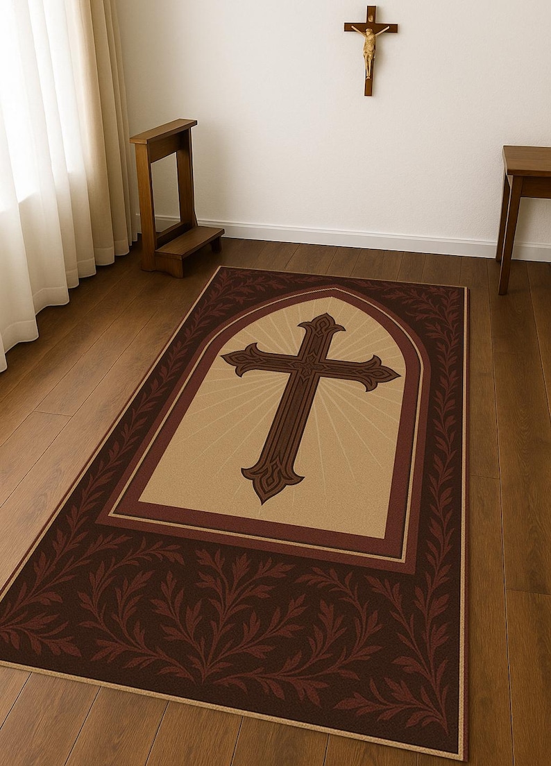 May include: A rectangular rug with a large brown cross design in the center, set against a beige background with radiating lines. The rug has a dark brown border with a repeating leaf pattern.
