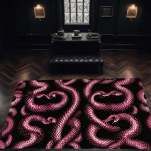 Op de afbeelding: Een roze en zwart tapijt met een slangenpatroon. Het tapijt ligt in een donkere kamer met een houten vloer.