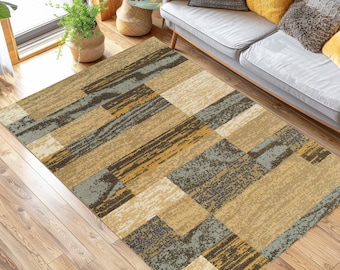 May include: A rectangular area rug with a geometric pattern of brown, beige, and blue squares and rectangles. The rug has a woven texture and is laid out on a hardwood floor.