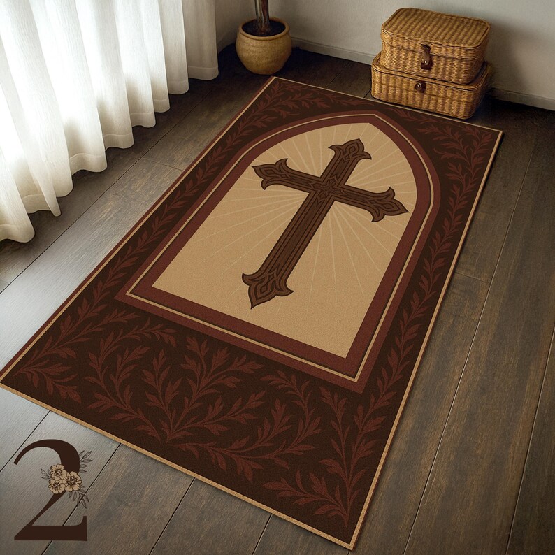 May include: Rectangular area rug featuring a large brown cross design within a light tan arch, radiating light. The cross is centered on the rug, framed by a dark brown border with a repeating leaf pattern. The rug is on a wooden floor.