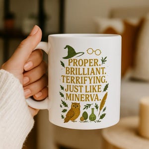 May include: White ceramic mug with the text "PROPER. BRILLIANT. TERRIFYING. JUST LIKE MINERVA." in green and gold lettering. The mug features illustrations of a witch hat, glasses, an owl, and potion bottles.