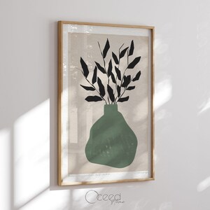 K&ouml;nnte beinhalten: Ein gerahmter Druck einer minimalistischen Illustration einer gr&uuml;nen Vase mit schwarzen Bl&auml;ttern. Der Hintergrund ist hellbeige.