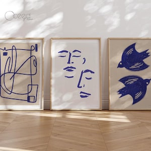 Könnte beinhalten: Drei gerahmte Drucke mit abstrakten Designs. Der erste Druck zeigt eine blaue Linienzeichnung auf beigefarbenem Hintergrund. Der zweite Druck zeigt zwei blaue Linienzeichnungen von Gesichtern auf weißem Hintergrund. Der dritte Druck zeigt zwei blaue Linienzeichnungen von Vögeln auf beigefarbenem Hintergrund.