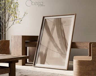 May include: A framed abstract art print with a beige and brown brushstroke design. The artwork is displayed in a light wood frame, leaning against a wooden bench. The image also shows wooden furniture and a plant.