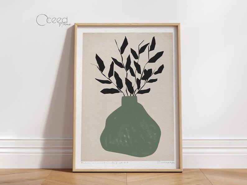 K&ouml;nnte beinhalten: Ein gerahmter Druck einer minimalistischen Illustration einer gr&uuml;nen Vase mit schwarzen Bl&auml;ttern. Der Text "Modern minimalist leaf sketch" ist unter dem Bild gedruckt.