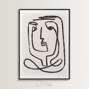 May include: Black and white line art print of a stylised face with a textured background. The print is framed in a black frame and has the signature "Cunanan" in the bottom right corner.