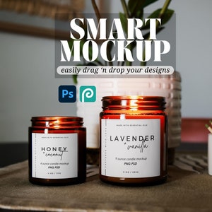 May include: Two amber glass candle jars with white labels. The smaller jar is labeled "Honey + Coconut" and the larger jar is labeled "Lavender + Vanilla". Both jars have a warm glow from the lit candles inside.