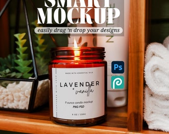 May include: A brown glass candle jar with a white label that reads "LAVENDER + vanilla" and "9 ounce candle mockup PNG PSD 9 OZ / 255G". The candle is lit and the flame is visible. The candle is on a wooden shelf with other items.