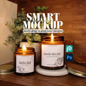 Peut inclure: Deux bougies en verre ambré à la cire de soja avec des étiquettes. La plus grande bougie a une étiquette blanche avec le texte "smells like fall" et un dessin de fruits d'automne. La plus petite bougie a une étiquette blanche avec le texte "hello fall". Les deux bougies sont allumées.