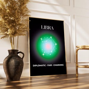 May include: A framed Libra zodiac sign art print. The black background features a green and pink gradient with the Libra constellation in white. The words "LIBRA" and "DIPLOMATIC • FAIR • CHARMING" are also displayed.