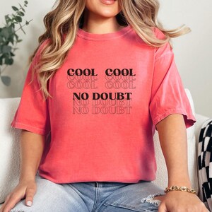 May include: A pink t-shirt with the text "COOL COOL COOL COOL NO DOUBT NO DOUBT NO DOUBT" printed on the front.