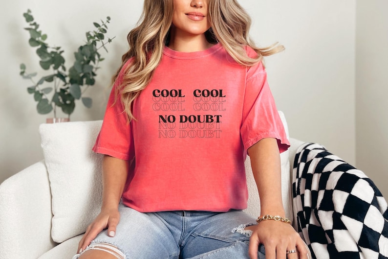 May include: A pink t-shirt with the text "COOL COOL COOL COOL NO DOUBT NO DOUBT NO DOUBT" printed on the front.