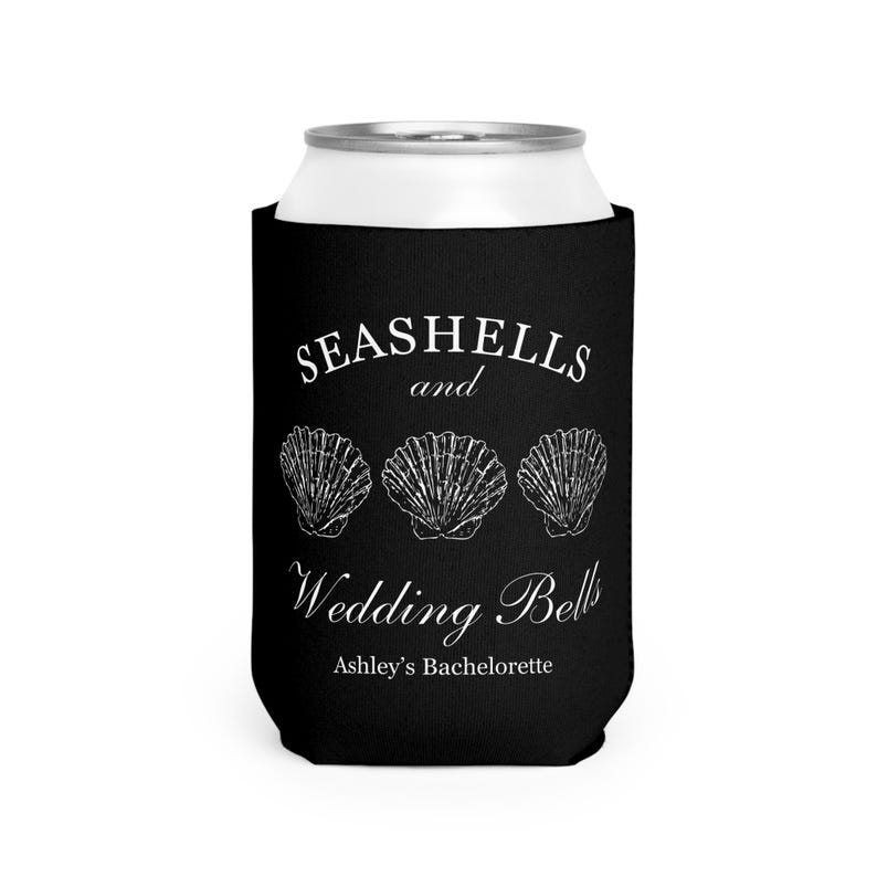 Może przedstawiać: Czarny kubek na puszkę z białym tekstem i ilustracjami muszli. Tekst brzmi "Seashells and Wedding Bells" z "Ashley's Bachelorette" poniżej. Projekt zawiera trzy ilustracje muszli.