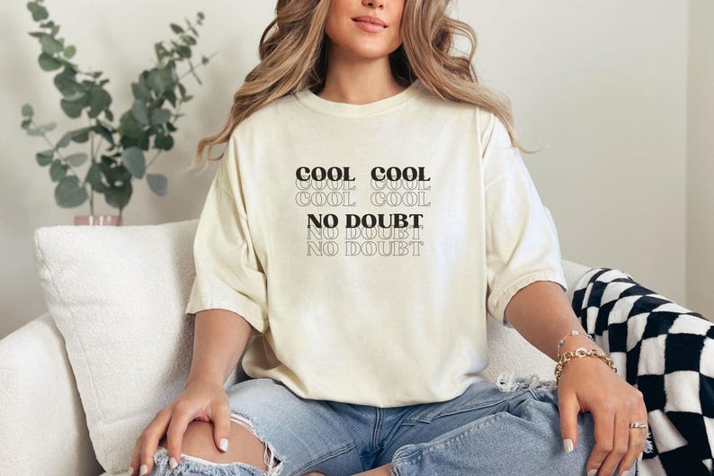 May include: A white t-shirt with the text "COOL COOL COOL COOL NO DOUBT NO DOUBT" printed in black.