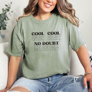 May include: A green t-shirt with the text "Cool Cool Cool Cool No Doubt No Doubt No Doubt" printed on the front.