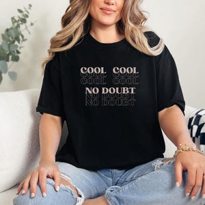 May include: A black t-shirt with the text "COOL COOL COOL COOL NO DOUBT NO DOUBT NO DOUBT" in a retro font.