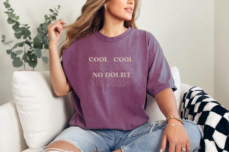 May include: A purple t-shirt with the text "Cool Cool Cool No Doubt No Doubt No Doubt" printed on the front.