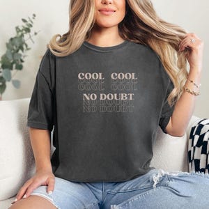 May include: A black cropped t-shirt with the text "COOL COOL COOL COOL NO DOUBT NO DOUBT" printed in a light pink color.