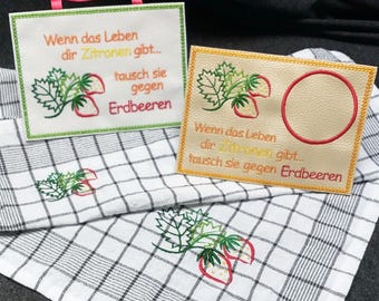 May include: Embroidered strawberry-themed kitchen decor. Two rectangular plaques with the text "Wenn das Leben dir Zitronen gibt... tausch sie gegen Erdbeeren" and strawberry illustrations. A checkered kitchen towel with matching strawberry embroidery.