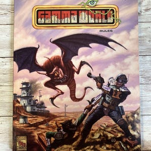 May include: A book cover for the Gamma World role-playing game. The cover features a futuristic scene with a winged creature attacking a human character. The text on the cover reads "Gamma World Rules".