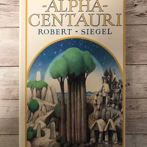 May include: A vintage paperback book titled "Alpha Centauri" by Robert Siegel. The cover features a colorful illustration of a fantastical landscape with a large tree, rocky cliffs, and a small village.
