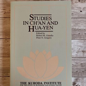 May include: A light blue book cover with the title "Studies in Ch'an and Hua-Yen" and the text "Edited by Robert M. Gimello Peter N. Gregory"  The cover also features a pink lotus flower and the text "The Kuroda Institute for the Study of Buddhism and Human Values Studies in East Asian Buddhism No. 1"