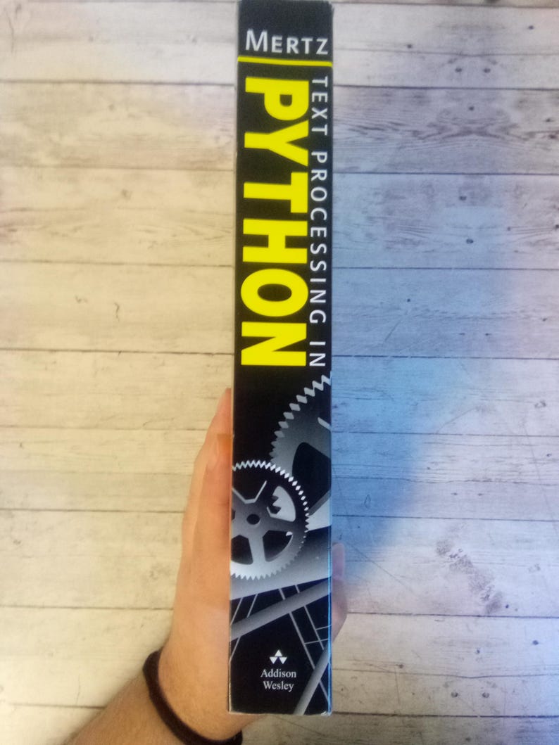 May include: A black book spine with the title "PYTHON" in large yellow letters. The book is titled "TEXT PROCESSING IN" and has the author's name "MERTZ" at the top. The publisher's logo is at the bottom.