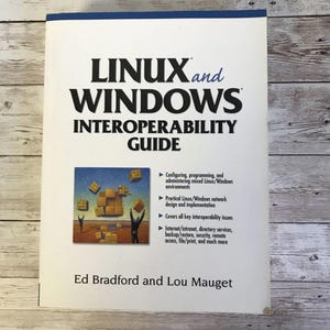 May include: A book titled "Linux and Windows Interoperability Guide" by Ed Bradford and Lou Mauget. The cover features an illustration of two people holding up boxes, representing the integration of Linux and Windows operating systems.