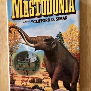 May include: A vintage book cover featuring a yellow title "MASTODONIA" with the text "A NOVEL BY CLIFFORD D. SIMAK" below. The cover art depicts a brown mammoth with large tusks standing in a forest setting with a small house in the background.