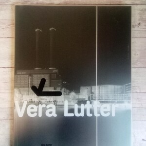 Puede incluir: Portada de libro con una fotografía en blanco y negro de un paisaje industrial con dos chimeneas. El título "Vera Lutter" está en letras blancas, con el subtítulo "Inside In" debajo.