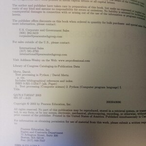 May include: A printed page with text from a book. The text includes contact information for sales and copyright details. The book's title is "Text processing in Python" by David Mertz. The ISBN is 0-321-11254-7.