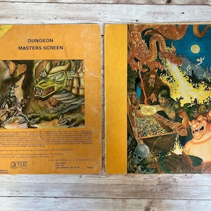 May include: A vintage Dungeons & Dragons game master's screen with a yellow background and a green dragon illustration on the front. The back of the screen has text that reads "Dungeon Masters Screen" and "For Advanced D&D Game".