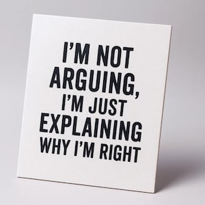Op de afbeelding: Een wit rechthoekig bord met zwarte tekst: "I'M NOT ARGUING, I'M JUST EXPLAINING WHY I'M RIGHT." Het bord staat schuin tegen een effen witte achtergrond.