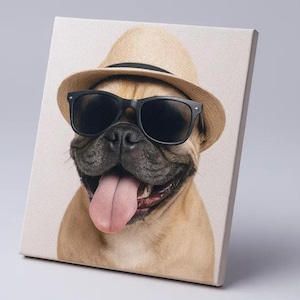 Op de afbeelding: Canvas print van een bruine hond met een strohoed en een zwarte zonnebril. De tong van de hond is zichtbaar. De afbeelding staat op een witte achtergrond.