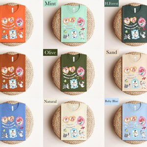 The image is a collage of nine different t-shirt designs, each with a unique color and pattern. The t-shirts are displayed on a woven basket, creating a visually appealing arrangement.