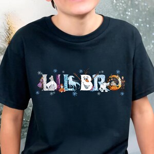 A person wearing a black t-shirt with a graphic design featuring characters from the Disney movie Frozen.