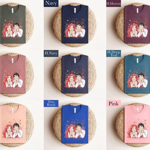 The image is a collage of nine t-shirts, each with a different color and design, arranged in a 3x3 grid. The t-shirts feature illustrations of two people, one male and one female, along with hearts. The t-shirts are displayed on a woven mat, and the text labels the different colors and designs of the t-shirts.