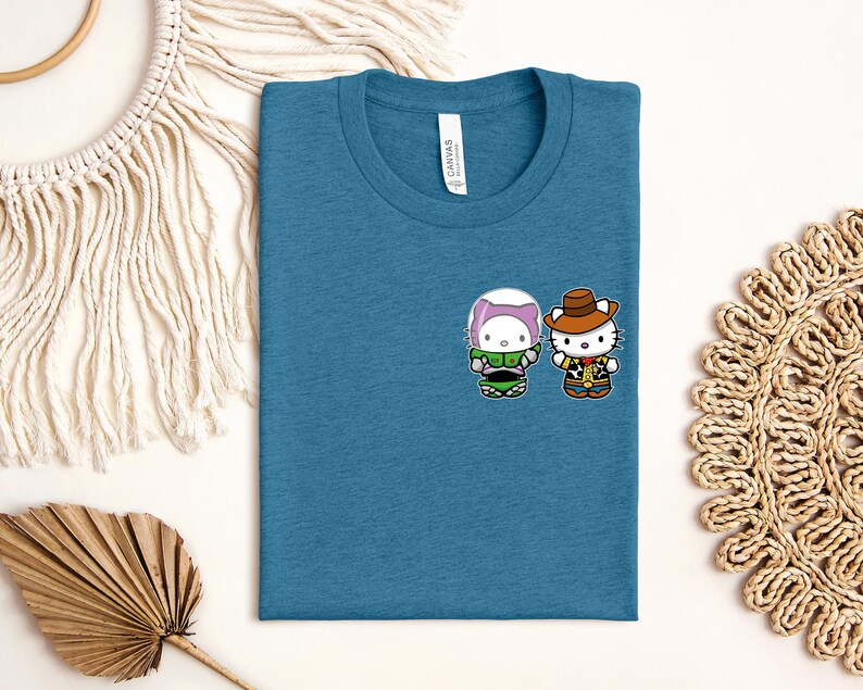 a blue t-shirt with a cartoon character design, along with some decorative elements such as a macrame wall hanging, a woven mat, and a leaf.