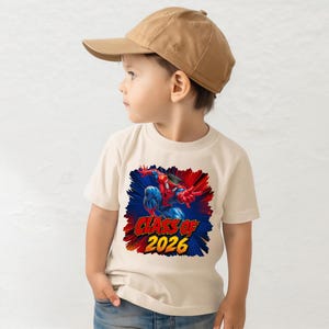 A young boy wearing a baseball cap and a t-shirt with a graphic of Spider-Man.