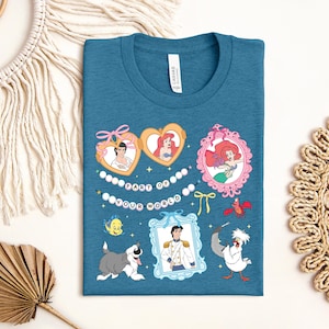 a blue t-shirt with a colorful graphic design, including illustrations of characters from Disney movies and a decorative string.