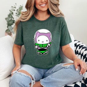 A woman wearing a green t-shirt with a Hello Kitty graphic is sitting on a couch.