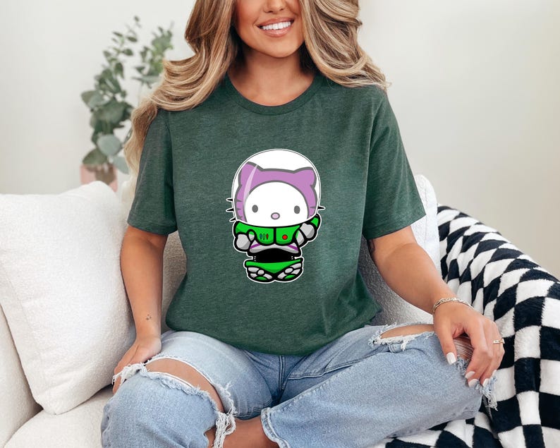 A woman wearing a green t-shirt with a Hello Kitty graphic is sitting on a couch.