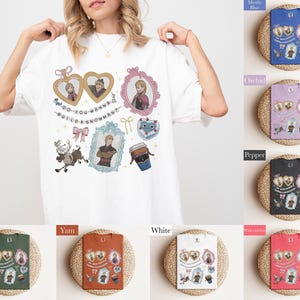 A woman wearing a white t-shirt with various cartoon characters and designs printed on it, posing with her arms raised.