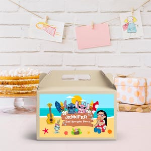 May include: A beige party favor box with a handle, featuring a colorful beach scene with cartoon characters, a guitar, and the text "Jennifer 2nd Birthday Party."
