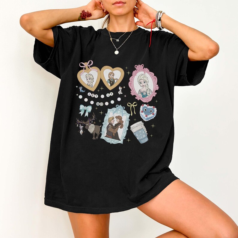 A person wearing a black t-shirt with various cartoon-style illustrations and text, including characters and objects such as hearts, a cup, and a mirror.