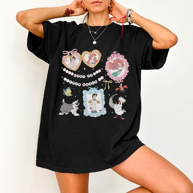 A person wearing a black t-shirt with various cartoon characters and designs printed on it.