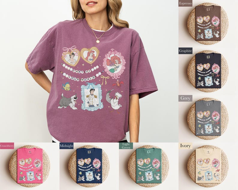 A woman wearing a purple t-shirt with various cartoon characters and designs, including a mermaid, a dog, and other whimsical elements.