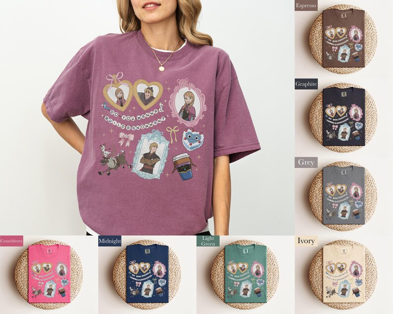 A woman wearing a purple t-shirt with various cartoon characters and designs, including a heart and a cup, is standing next to a display of different colored books or notebooks.