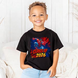 A young boy wearing a black t-shirt with a graphic of Spider-Man and the text "CLASS OF 2026" is smiling at the camera.