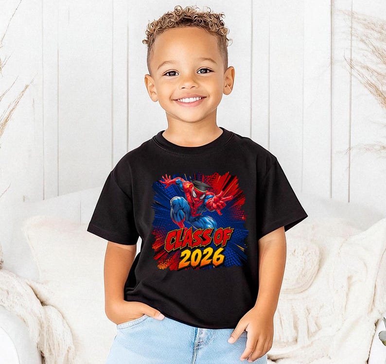 A young boy wearing a black t-shirt with a graphic of Spider-Man and the text "CLASS OF 2026" is smiling at the camera.